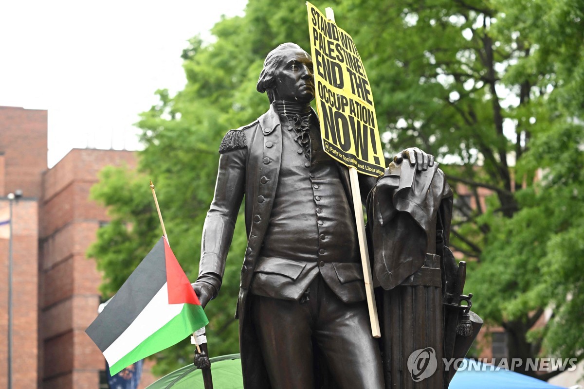 25일(현지시간) 미 워싱턴DC 조지워싱턴대의 조지 워싱턴 동상에 시위 팻말이 놓여 있다.