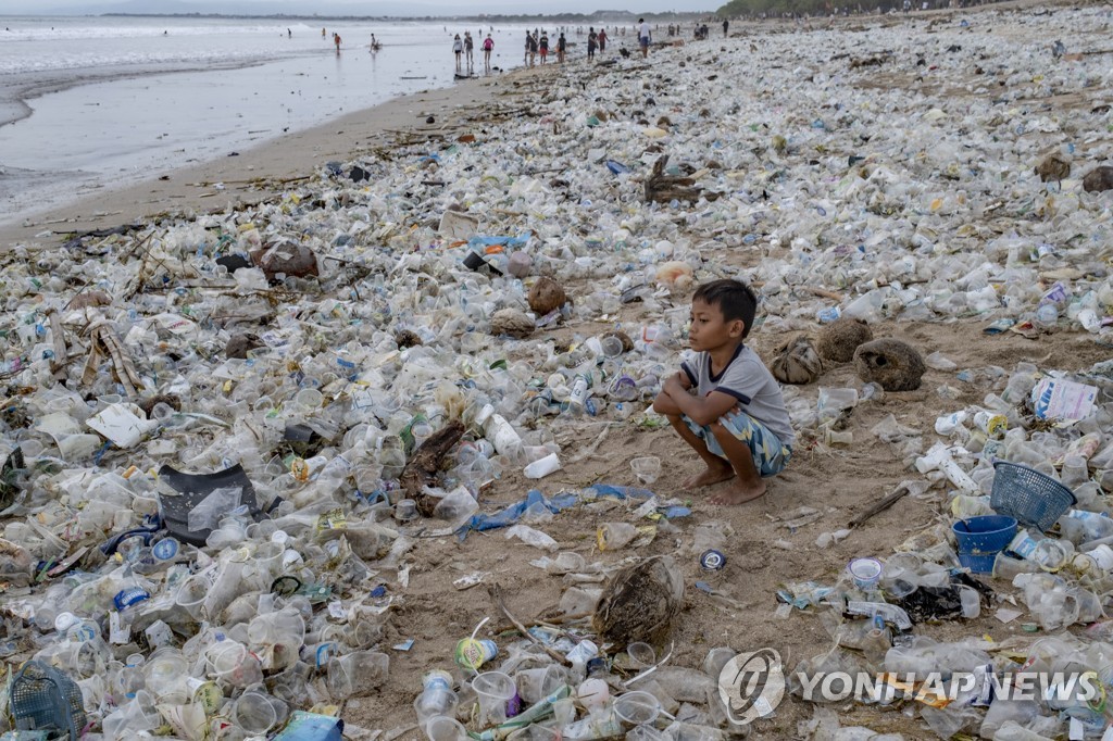 작년 12월 31일(현지시간) 쓰레기로 뒤덮인 인도네시아 발리섬 쿠타 해변에 꿇어앉은 소년의 모습