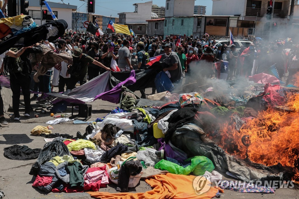25일(현지시간) 베네수엘라 등 이민자들의 천막과 옷가지를 불태우는 칠레 반이민 시위대