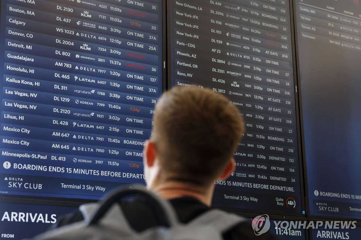 LA 공항에서 항공편 출도착 현황판 보는 승객