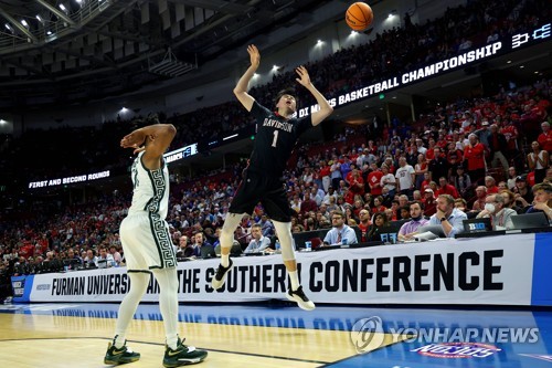 In this Getty Images photo, Lee Hyun-jung of the Davidson Wildcats (R) loses control of the ball against A.J. Hoggard of the Michigan State Spartans during the first round game of the West Region in the National Collegiate Athletic Association Division I Men's Basketball Tournament at Bon Secours Wellness Arena in Greenville, South Carolina, on March 18, 2022. (Yonhap)