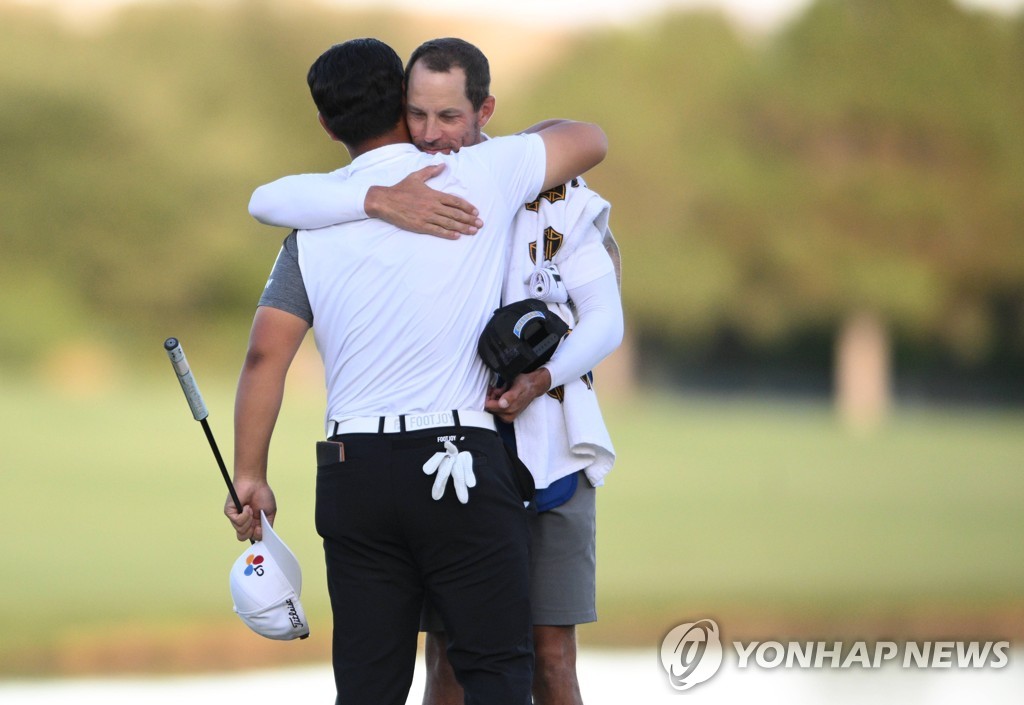 In this Getty Images photo, Kim Joo-hyung of South Korea (L) embraces his caddie Joe Skovron after winning the Shriners Children's Open at TPC Summerlin in Las Vegas on Oct. 9, 2022. (Yonhap)