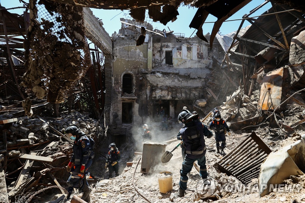 러시아군의 폭격으로 파괴된 마리우폴 극장 내에서 잔해를 치우는 구급대원들