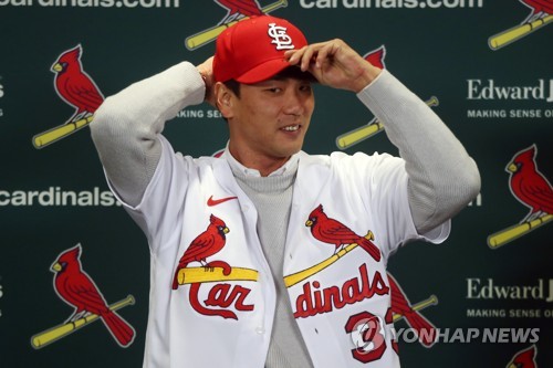 In this UPI photo, South Korean pitcher Kim Kwang-hyun puts on his new St. Louis Cardinals cap during an introductory press conference at Busch Stadium in St. Louis on Dec. 17, 2019. (Yonhap)