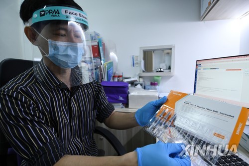싱가포르의 한 의사가 시노백 백신을 들어보이고 있다. 2021.7.6