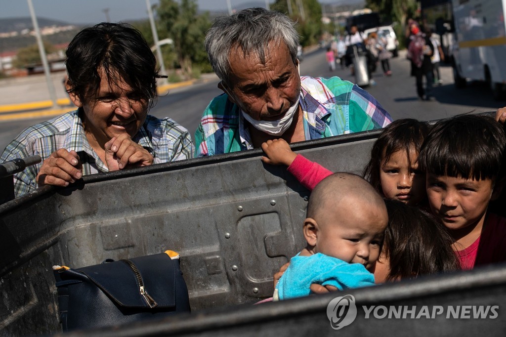 쓰레기통 안에 있는 모리아 난민캠프의 어린이들. 2020.9.11. [로이터=연합뉴스]