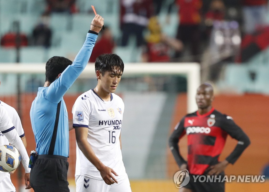 In this Reuters photo, Won Du-jae of Ulsan Hyundai FC (C) is shown a red card by referee Abdulrahman Ibrahim Al Jassim during the semifinal match at the Asian Football Confederation Champions League against Pohang Steelers at Jeonju World Cup Stadium in Jeonju, 240 kilometers south of Seoul, on Oct. 20, 2021. (Yonhap)
