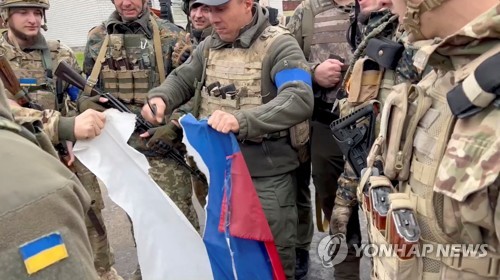 되찾은 하르키우에서 러시아 국기 찢어버리는 우크라이나군