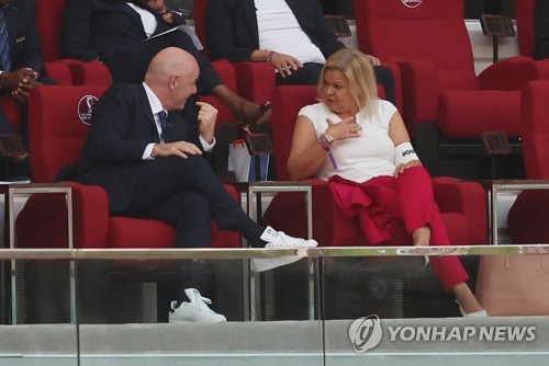 In this Reuters photo, German Interior Minister Nancy Faeser (R) wears an "One Love" armband next to FIFA President Gianni Infantino during a Group E match of the FIFA World Cup between Germany and Japan at Khalifa International Stadium in Al Rayyan, west of Doha, on Nov. 23, 2022. (Yonhap)