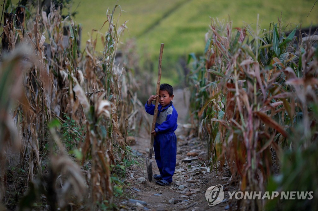2011년 황해도 속사리 집단농장에서 삽을 들고 있는 북한 소년