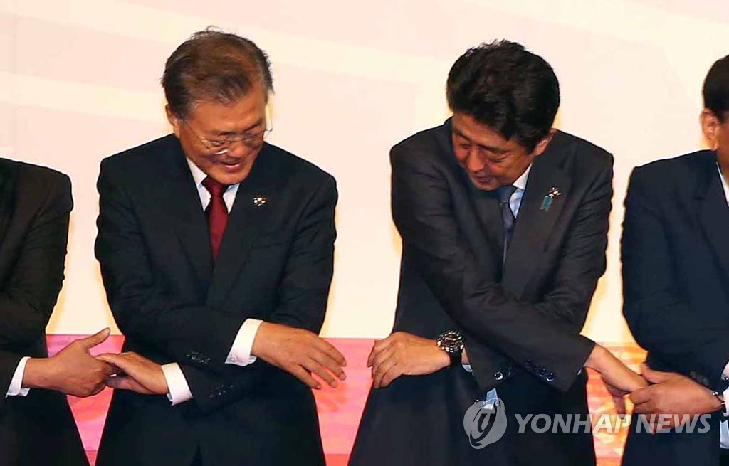 手を取り合う韓日首脳