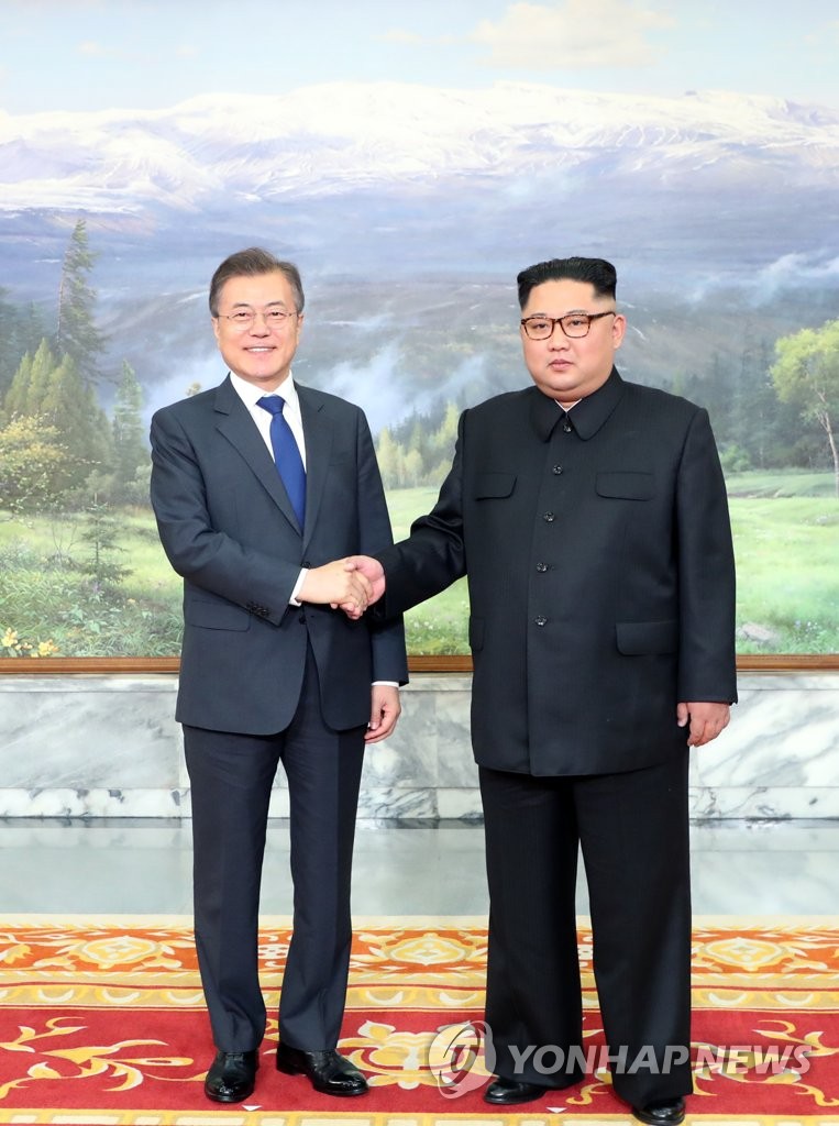 握手する文大統領（左）と金委員長（青瓦台提供）＝２６日、ソウル（聯合ニュース）