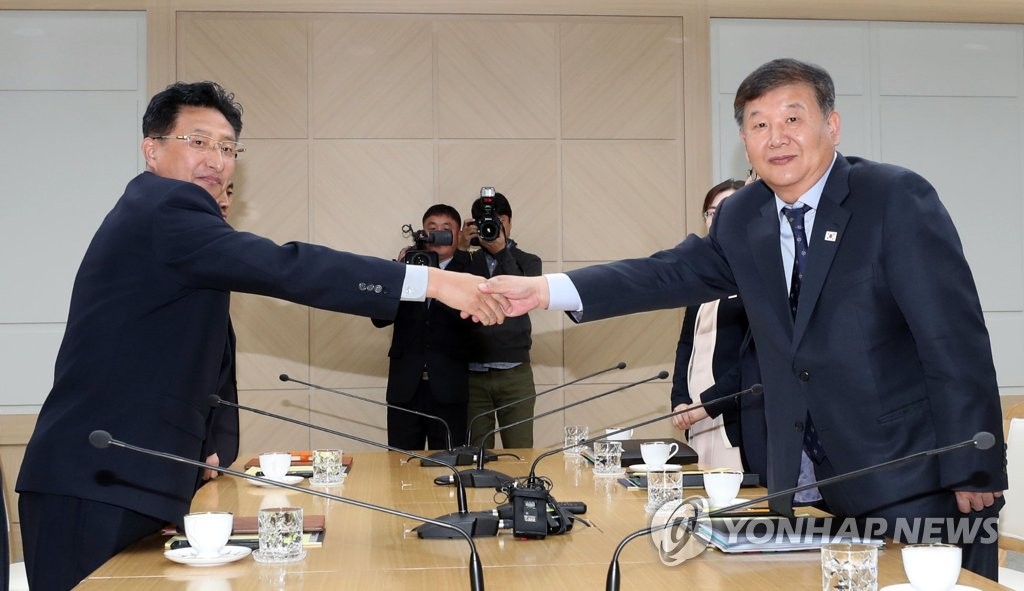 北朝鮮の南北共同連絡事務所で開かれた体育当局会談で握手する韓国代表（右）と北朝鮮代表（写真共同取材団）＝２日、開城（聯合ニュース）