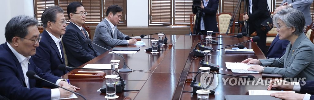 President Moon Jae-in (2nd from L) receives a briefing from Foreign Minister Kang Kyung-wha (R) on the results of her trip to Hungary on June 3, 2019. (Yonhap)