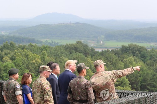 U.S. President Donald Trump (3rd from R) and South Korean President Moon Jae-in (C) peer into North Korea from Observation Post Ouellette at the DMZ on June 30, 2019. (Yonhap)