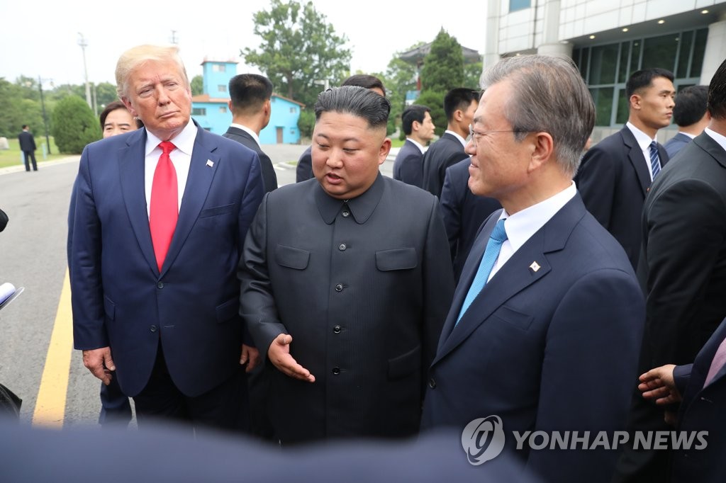 Le président Moon Jae-in (à dr.), le dirigeant nord-coréen Kim Jong-un (au centre) et le président américain Donald Trump se rencontrent le dimanche 30 juin 2019 au village de la trêve de Panmunjom.