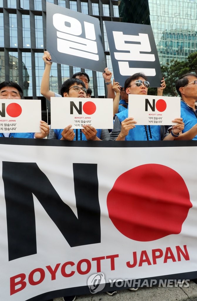 Members of the Confederation of Korean Government Employees hold up signs denouncing Japan's expanded export restrictions on South Korea and calling for a boycott campaign against Japanese goods during a rally in front of the Japanese Embassy in Seoul on Aug. 6, 2019. (Yonhap)