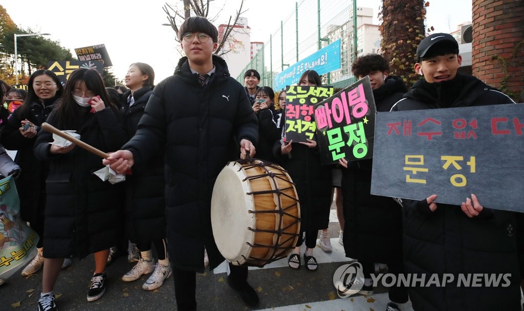 Using a traditional Korean drum and signs, high school students cheer for seniors taking this year's College Scholastic Aptitude Test at a high school in eastern Seoul on Nov. 14, 2019. (Yonhap)