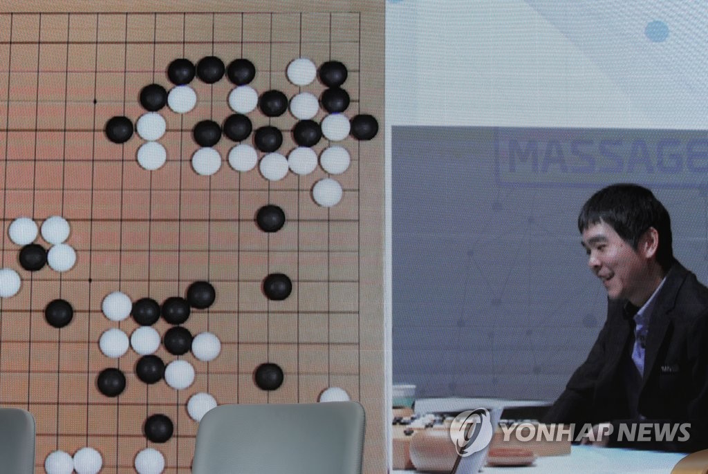 South Korean Go player Lee Se-dol (R) smiles during a match against artificial intelligence program HanDol in Seoul on Dec. 18, 2019. (Yonhap)