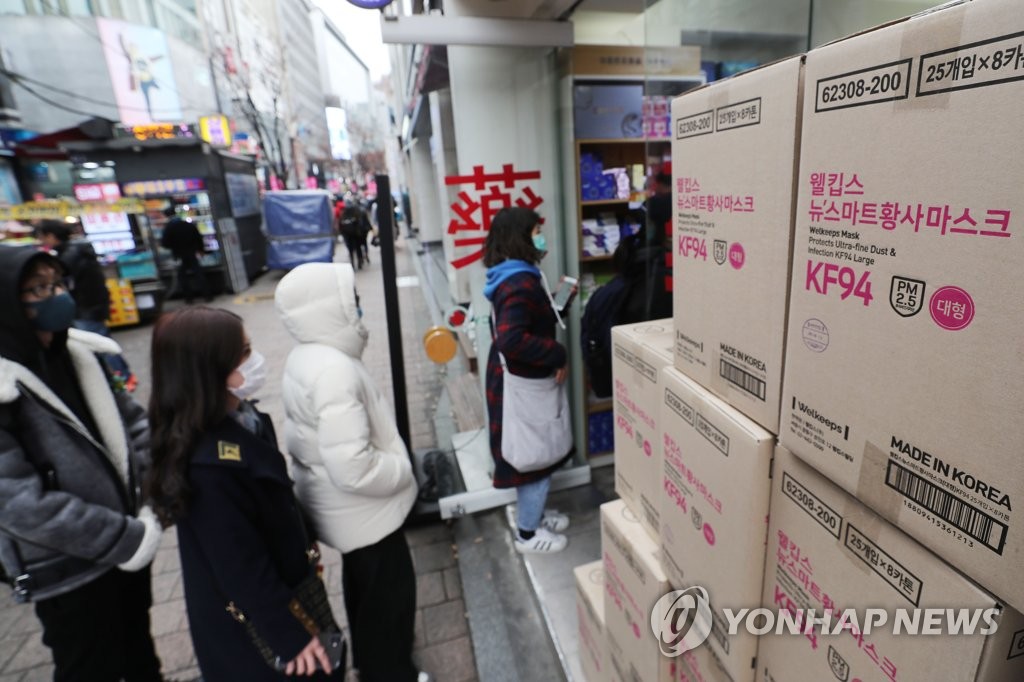 People assumed to be foreign tourists queue at a pharmacy in Myeongdong in central Seoul to buy masks on Jan. 27, 2020. (Yonhap)