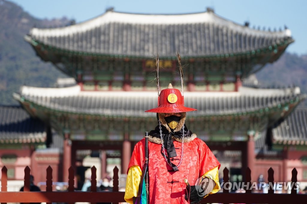 A guard wearing a mask with a goblin-pattern embroidery stands in front of Gwanghwamun on Feb. 6, 2020, in this file photo. (Yonhap)