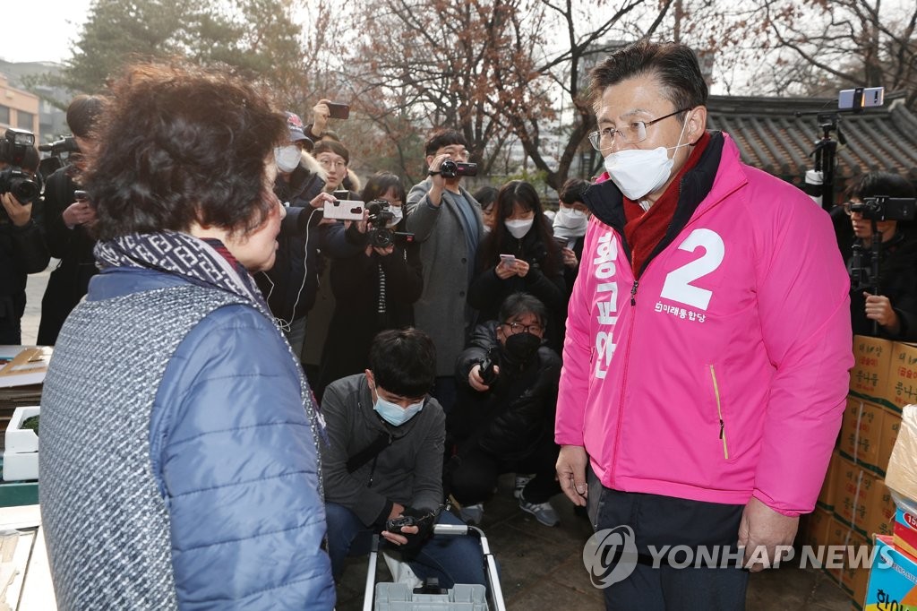 Hwang Kyo-ahn (R), head of the main opposition United Front Party, talks with a Seoul citizen on Feb. 21, 2020, as he prepares to run in the April 15 general elections. (Yonhap)