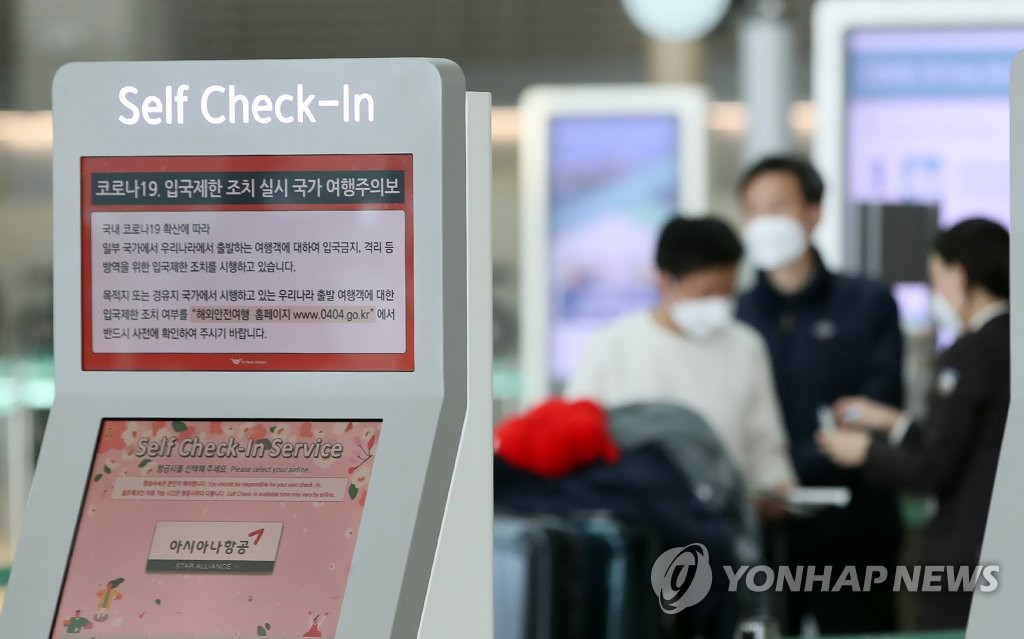 仁川国際空港の自動チェックイン機に世界各国・地域の韓国からの入国制限などに関する情報が掲載されている＝１８日、仁川（聯合ニュース）