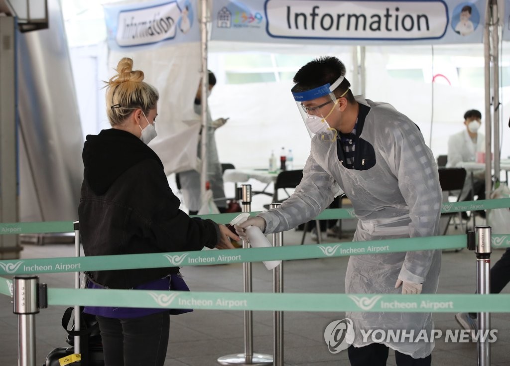 A tourist from Europe is tested for COVID-19 at a walk-through test center temporarily set up outside a terminal of Incheon International Airport, west of Seoul, on March 31, 2020. (Yonhap)