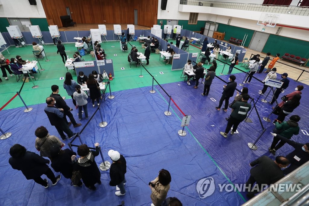 Voters form a long line to cast their ballots at a polling station in Seoul on April 15, 2020, as South Koreans began voting the same day to elect a new parliament amid the outbreak of the new coronavirus. (Yonhap)