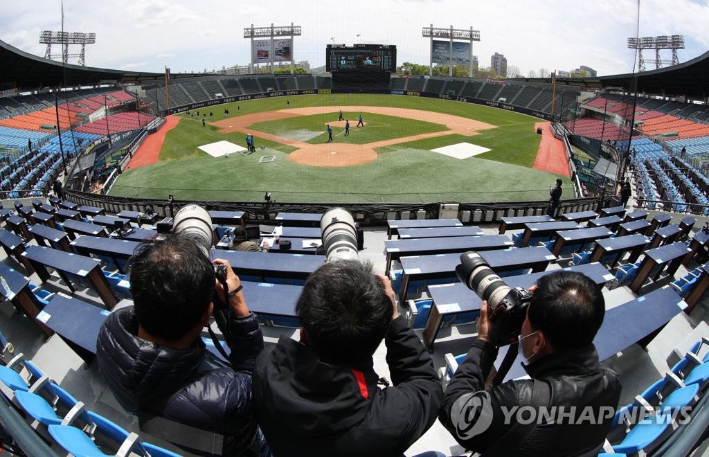 Photojournalists take shots of a Korea Baseball Organization preseason game between the LG Twins and the Doosan Bears at Jamsil Stadium in Seoul on April 21, 2020. (Yonhap)