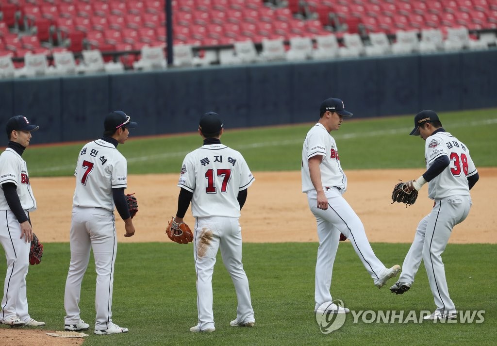 In this file photo from April 22, 2020, Kim Dae-han (R) and Lee Yong-chan (2nd from R) of the Doosan Bears bump their feet in celebration of a 5-0 victory over the Kiwoom Heroes in a Korea Baseball Organization preseason game at Jamsil Stadium in Seoul. (Yonhap)