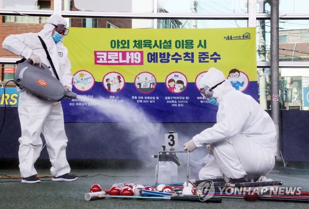 Health workers disinfect sports equipment at a community sports center in Seoul on April 23, 2020. (Yonhap)
