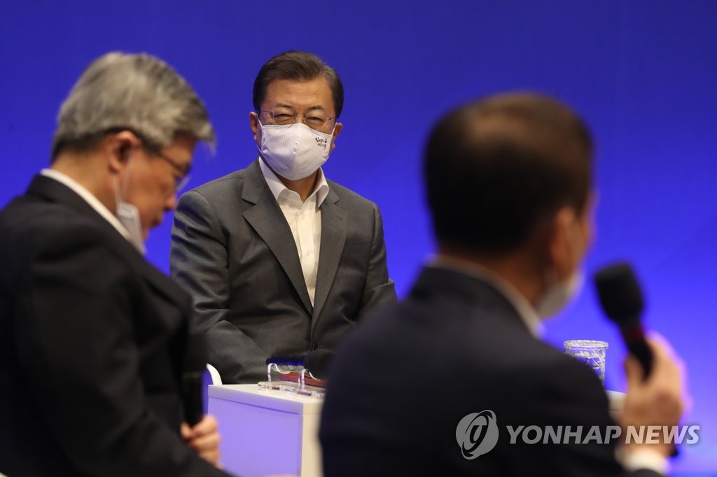 President Moon Jae-in, wearing a mask, listens to a hotel representative's comments at Grand Walkerhill Seoul on April 29, 2020. (Yonhap)