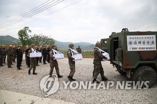 This undated photo, provided by the defense ministry on May 14, 2020, shows soldiers carrying boxes containing the recently excavated remains of soldiers killed in action at Arrowhead Ridge in the South Korean border town of Cheorwon next to the Demilitarized Zone bisecting the two Koreas. This year's excavation kicked off on April 20. (PHOTO NOT FOR SALE) (Yonhap)