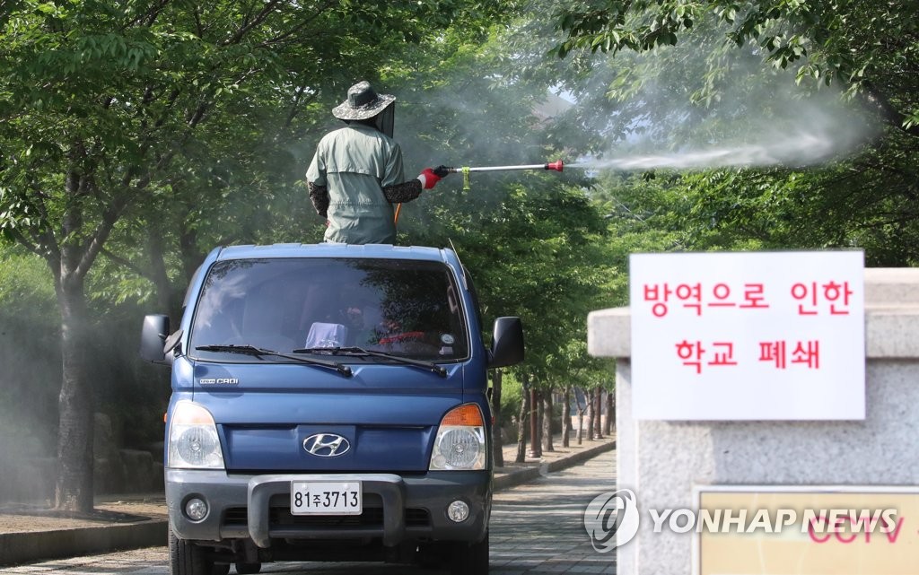 An employee of Daegu Agricultural Meister High School in Daegu, 300 kilometers southeast of Seoul, disinfects the school grounds from a truck on May 21, 2020, after a senior student who was admitted to a dormitory tested positive for COVID-19. (Yonhap)