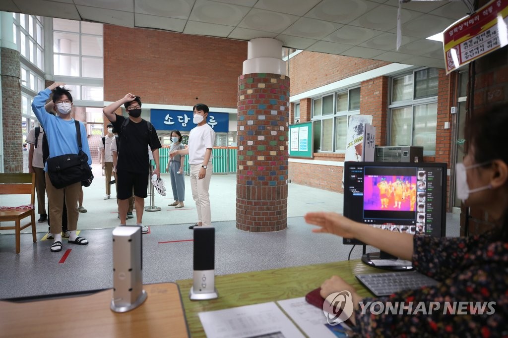Students have their body temperatures checked at a high school in Gwangju, 330 kilometers south of Seoul, on June 3, 2020. (Yonhap)