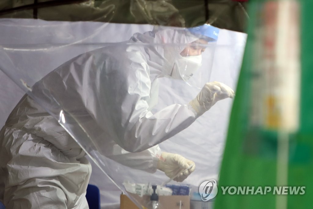Medical officials carry out new coronavirus tests on visitors at a makeshift clinic in Gwangju, 330 kilometers south of Seoul, on July 24, 2020. (Yonhap)