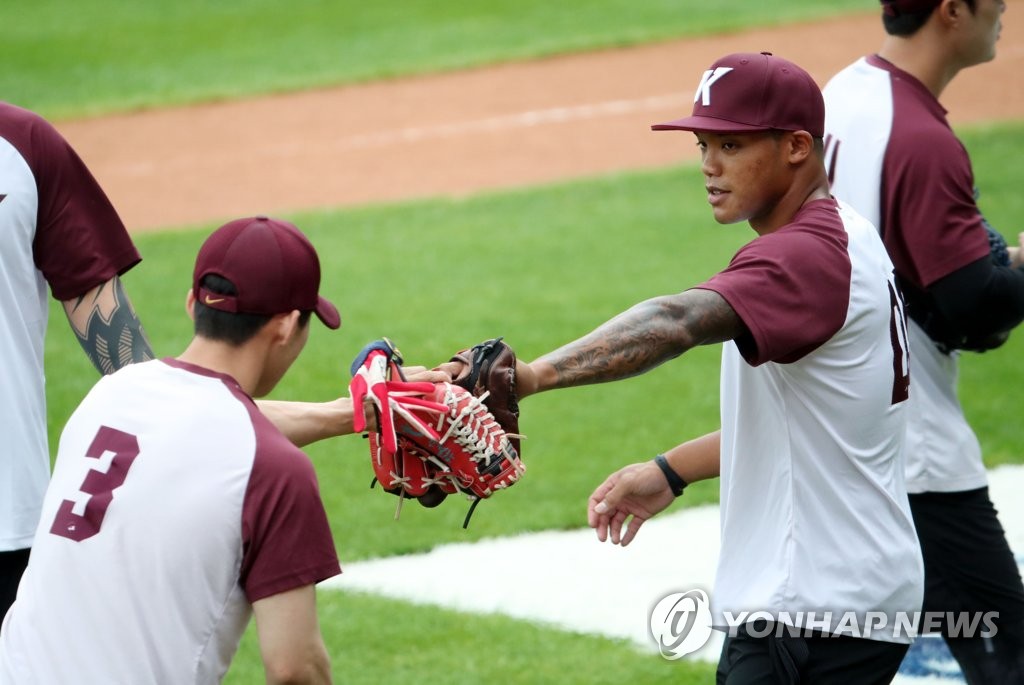 Addison Russell of the Kiwoom Heroes (R) bumps gloves with his teammate Kim Hye-seong during a fielding practice ahead of a Korea Baseball Organization regular season game against the Doosan Bears at Jamsil Baseball Stadium in Seoul on July 28, 2020. (Yonhap)