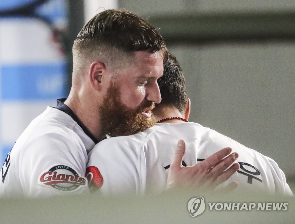 In this file photo from July 31, 2020, Dan Straily of the Lotte Giants (L) embraces teammate Jeon Jun-woo in the dugout after the top of the sixth inning of a Korea Baseball Organization regular season game against the Kia Tigers at Sajik Stadium in Busan, 450 kilometers southeast of Seoul. (Yonhap)