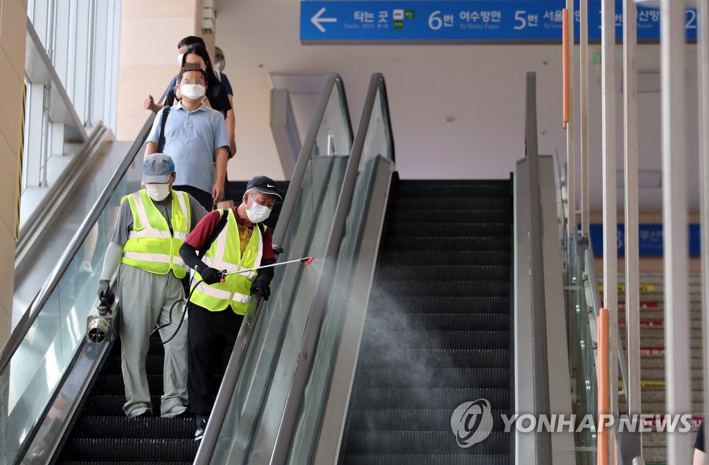Sanitary staff members disinfect escalators at Suncheon Station in Suncheon, 415 kilometers south of Seoul, on Aug. 24, 2020. (Yonhap)