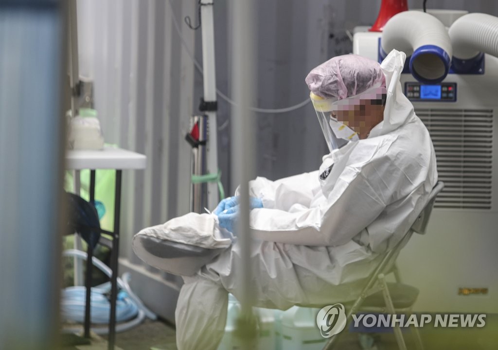 A medical worker takes a short break at a makeshift clinic located in Daejeon, 164 kilometers south of Seoul, on Aug. 26, 2020. (Yonhap)