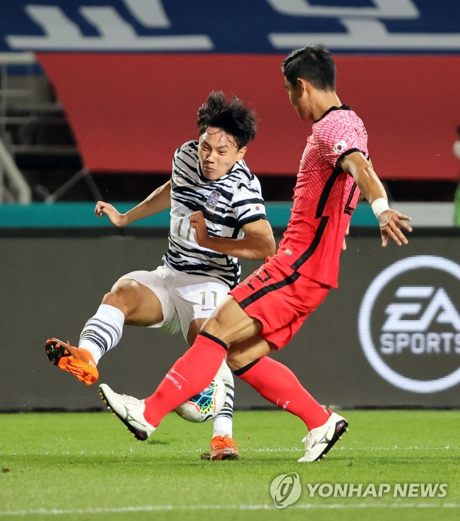 Cho Young-wook (L) of the South Korean men's under-23 national football team tries to make a pass past Lee Ju-yong of the senior national team during an exhibition match at Goyang Stadium in Goyang, Gyeonggi Province, on Oct. 9, 2020. (Yonhap)