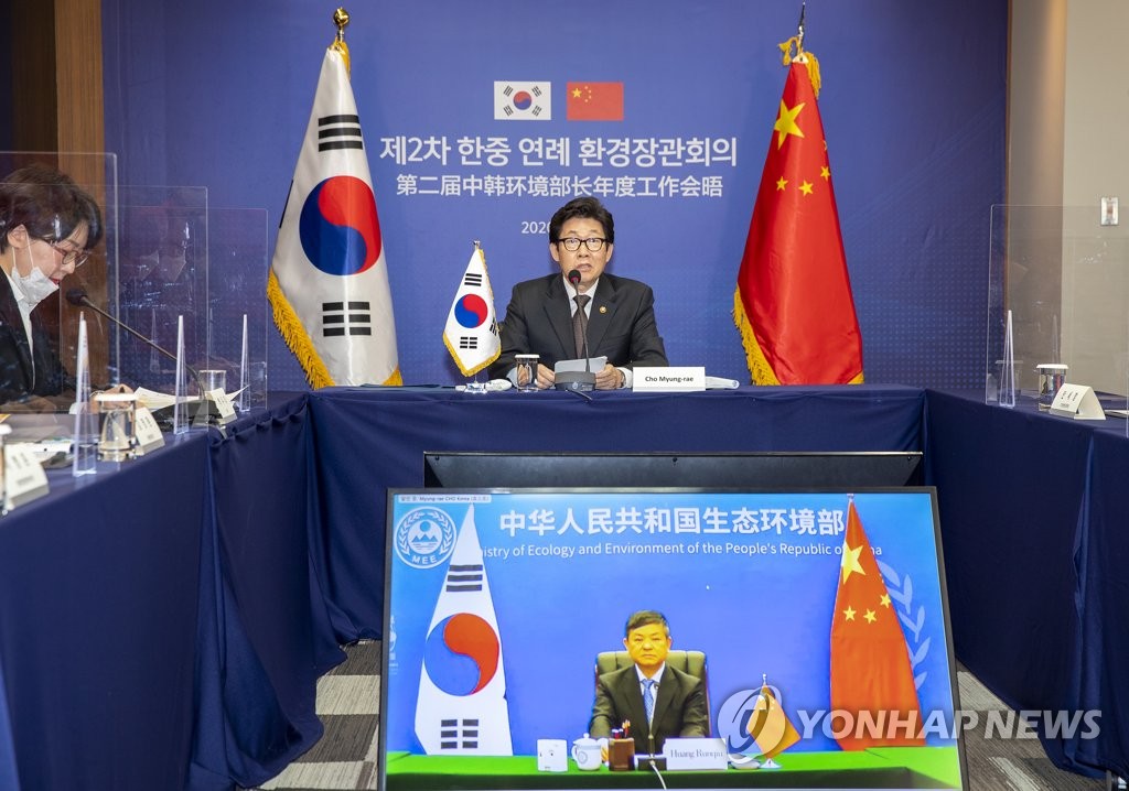 Environment Minister Cho Myung-rae (top) holds a virtual meeting with his Chinese counterpart Huang Runqiu (on screen) to discuss measures to reduce fine dust and achieve carbon neutrality on Nov. 11, 2020, in this photo provided by the Ministry of Environment. (PHOTO NOT FOR SALE) (Yonhap)