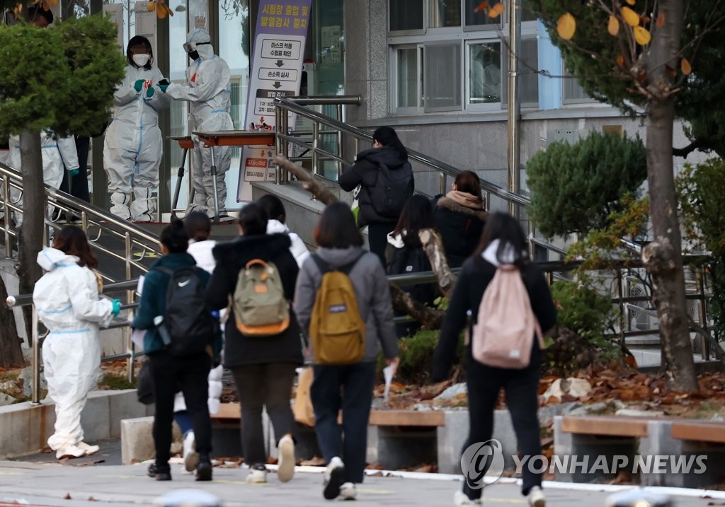 Applicants for a state-run teacher employment examination enter a test site in Seoul on Nov. 21, 2020. (Yonhap)