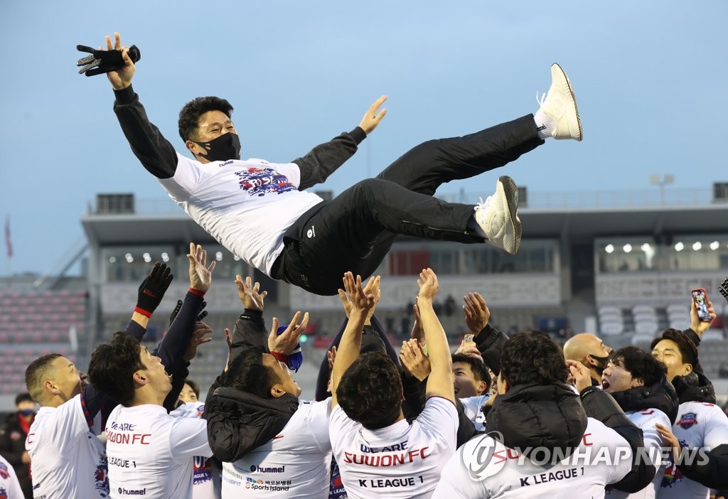 Suwon FC players toss their head coach Kim Do-kyun in the air to celebrate their promotion to the K League 1 after a 1-1 draw with Gyeongnam FC in their K League 2 promotion playoff match at Suwon Sports Complex in Suwon, 45 kilometers south of Seoul, on Nov. 29, 2020. (Yonhap)