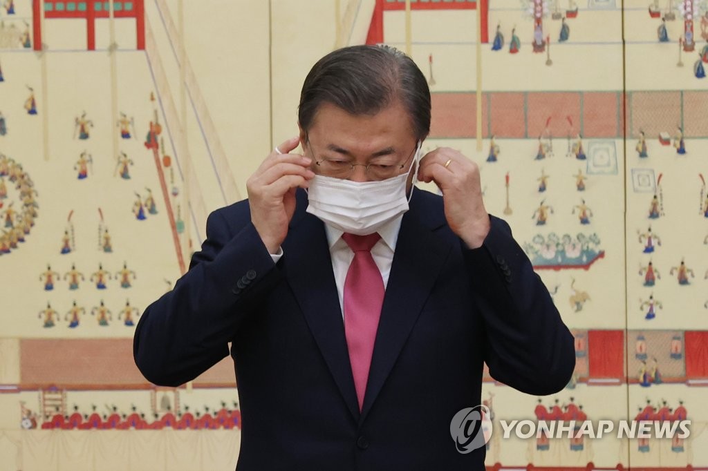 President Moon Jae-in takes off his mask for a commemorative photo with a group of newly appointed ambassadors during a ceremony at Cheong Wa Dae on Dec. 2, 2020. (Yonhap)