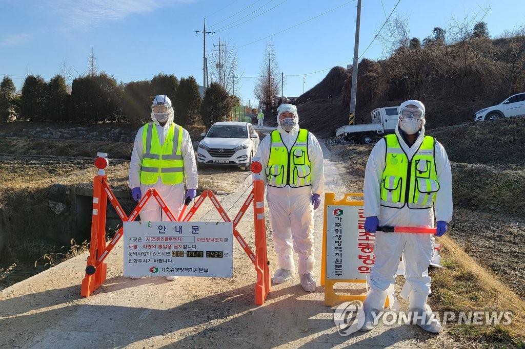 Quarantine officials block a road to a farm in Eumseong, North Chungcheong Province, on Dec. 8, 2020, due to an outbreak of virulent bird flu there. (Yonhap)