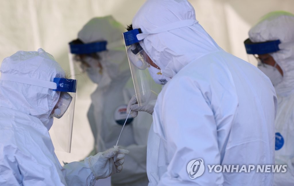 Medical employees work at a makeshift clinic in central Seoul on Dec. 16, 2020. (Yonhap)