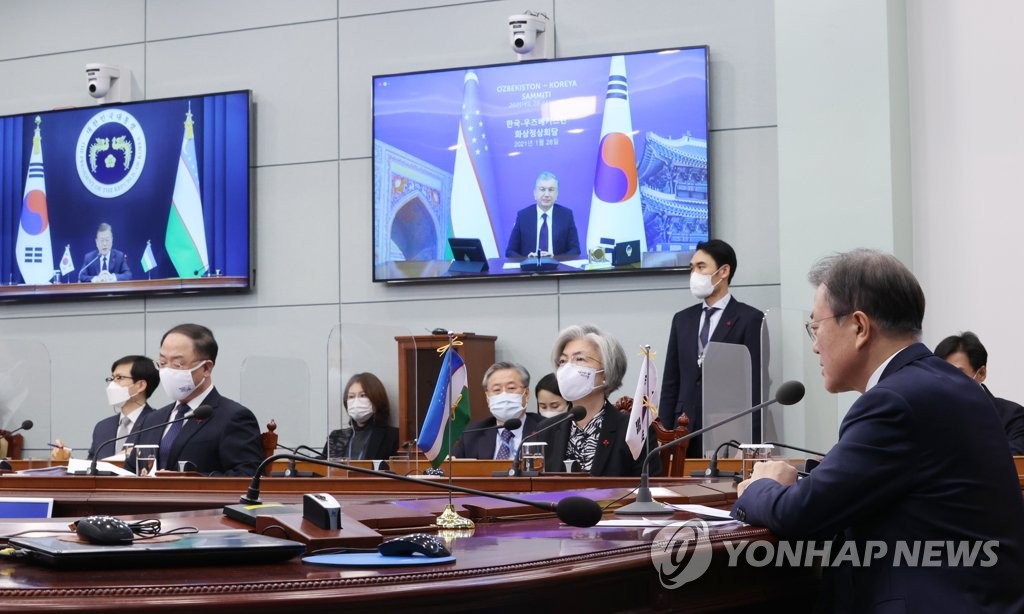 South Korean President Moon Jae-in greets Uzbek President Shavkat Mirziyoyev before holding summit talks via video links at Cheong Wa Dae in Seoul on Jan. 28, 2021. (Yonhap) 