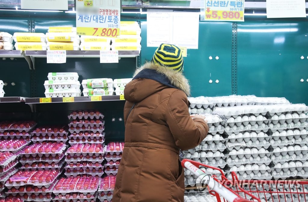 A shopper chooses a carton of eggs at a supermarket in Osan, 55 km south of Seoul, on Jan. 28, 2021. (Yonhap)